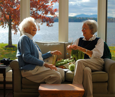 Deux femme souriante qui se font du tricot