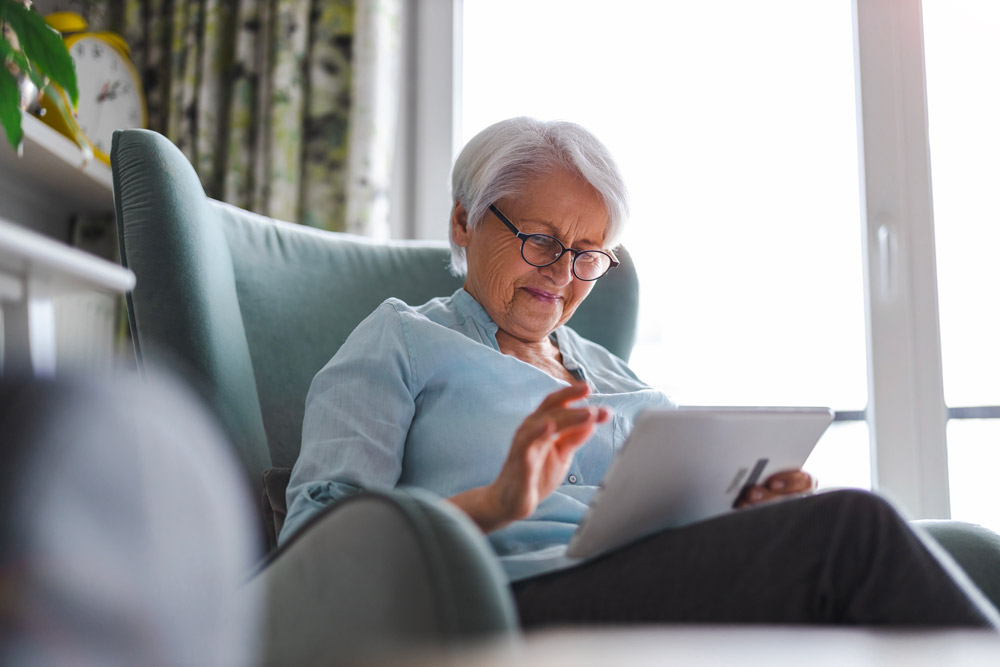 Femme ainée qui navigue sur une tablette électronique